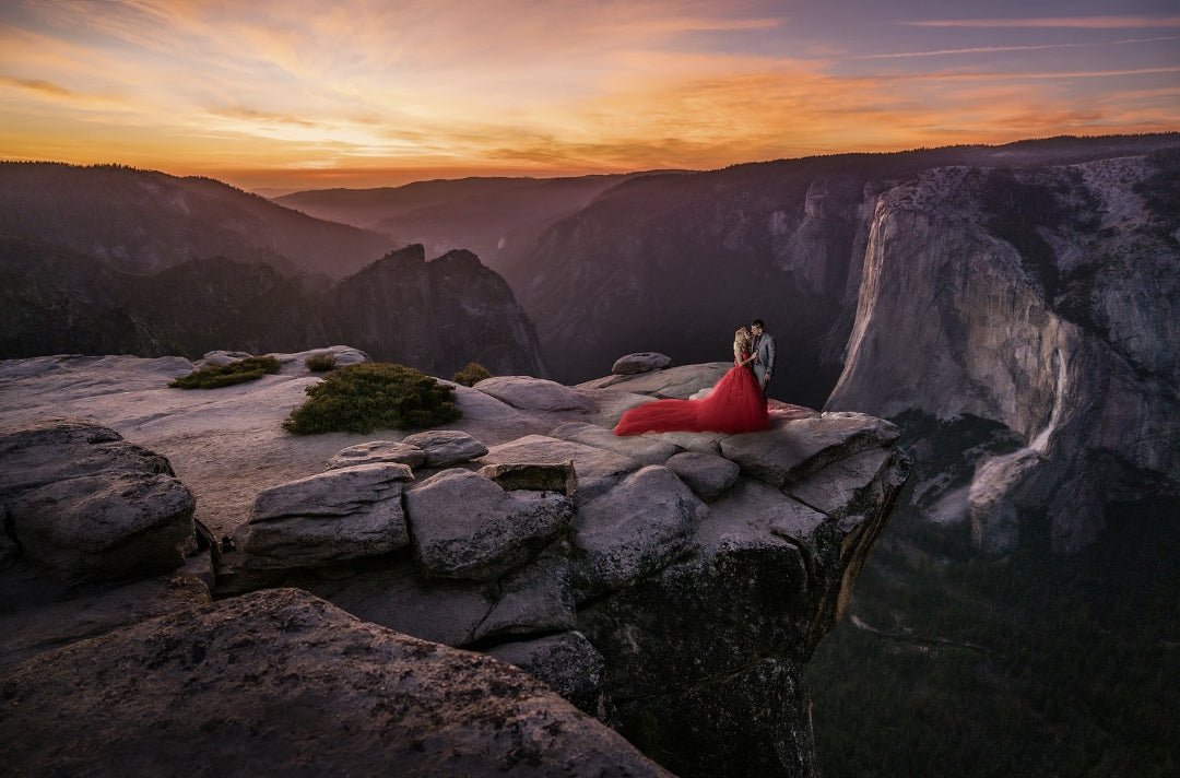 Dramatic photo of a couple posing for an engagement session on the edge of the cliff