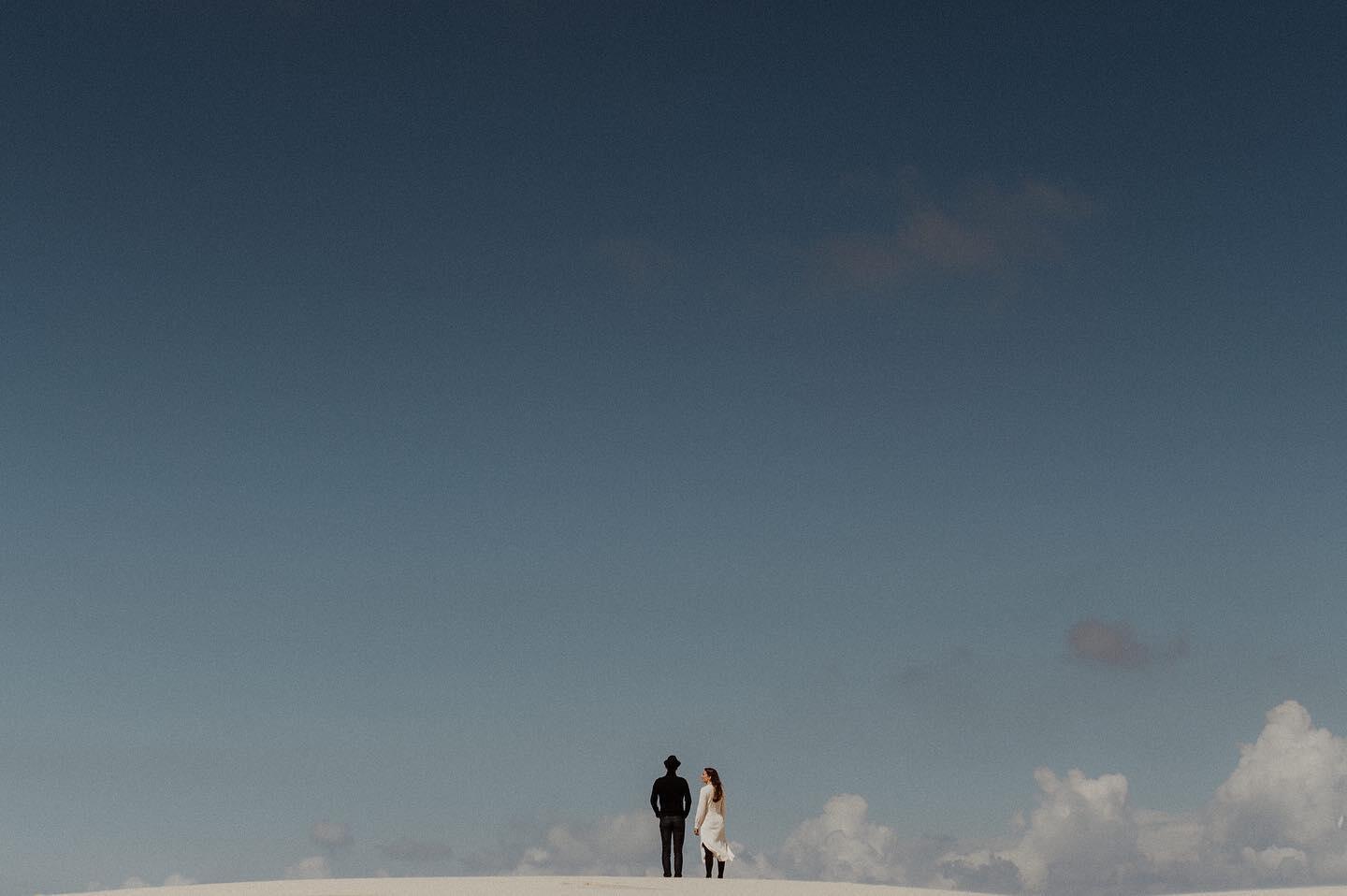 A couple posing with the sky as a backdrop