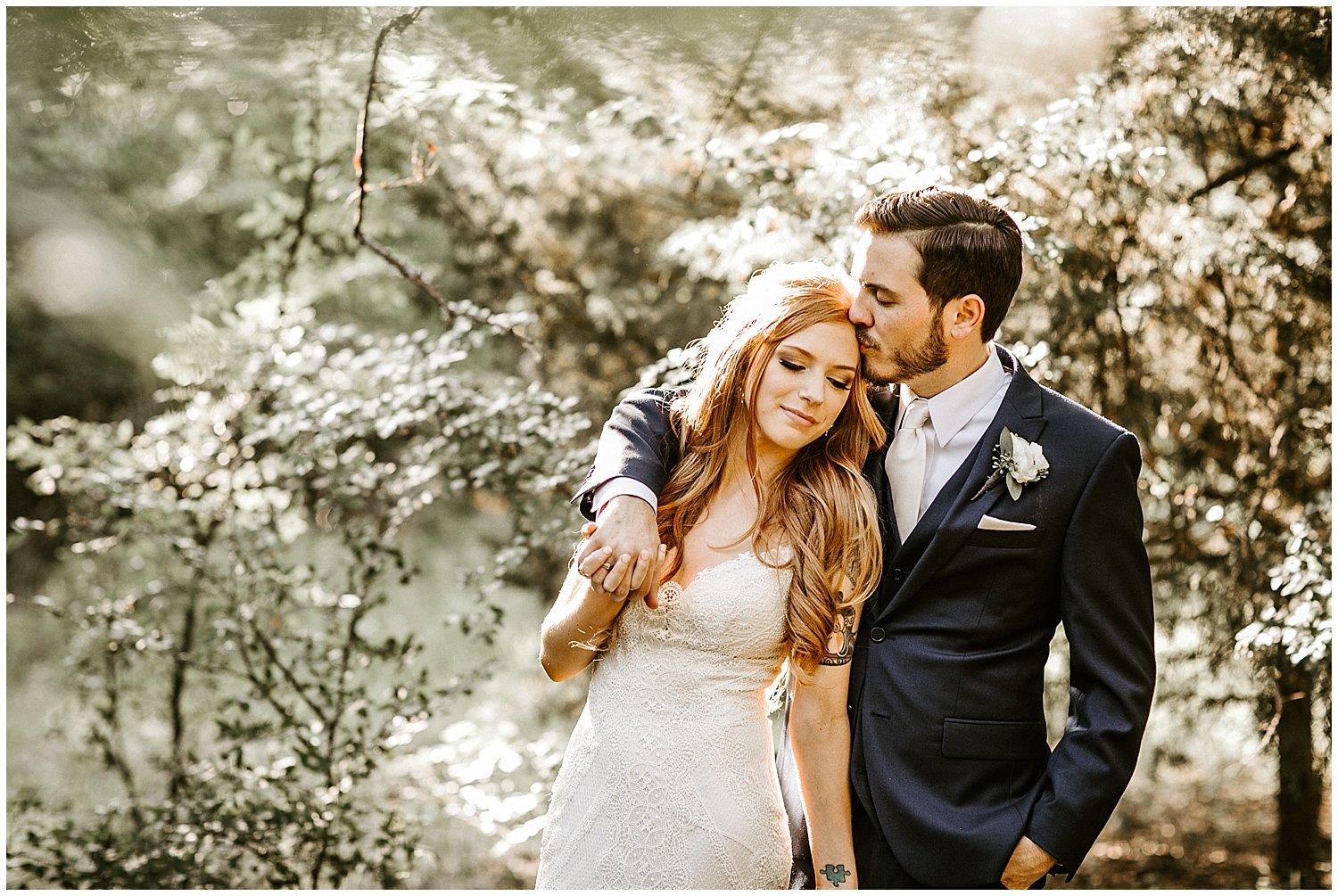 A wedding couple standing in the woods, in love. Brandi Allyse Photography