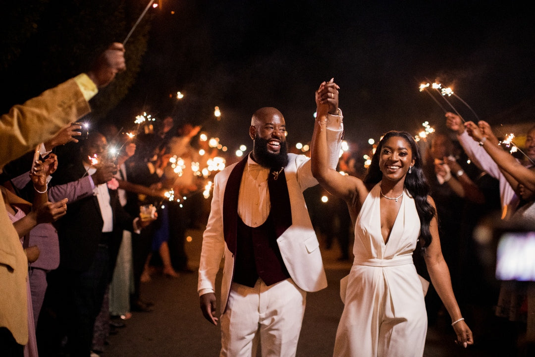 A black bride and groom make a sparkler exit after their wedding reception