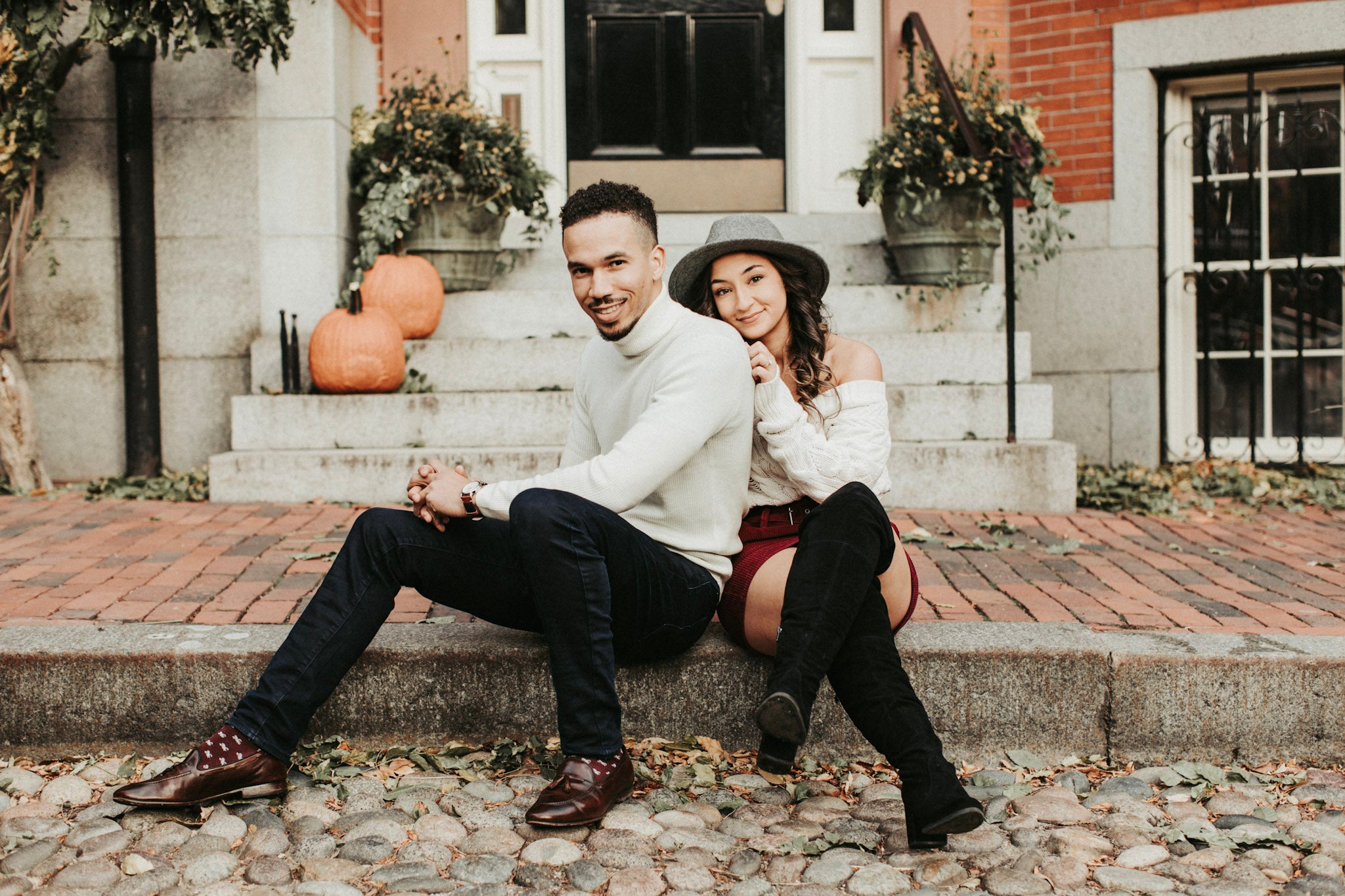 A couple posing while sitting in front of a doorway 