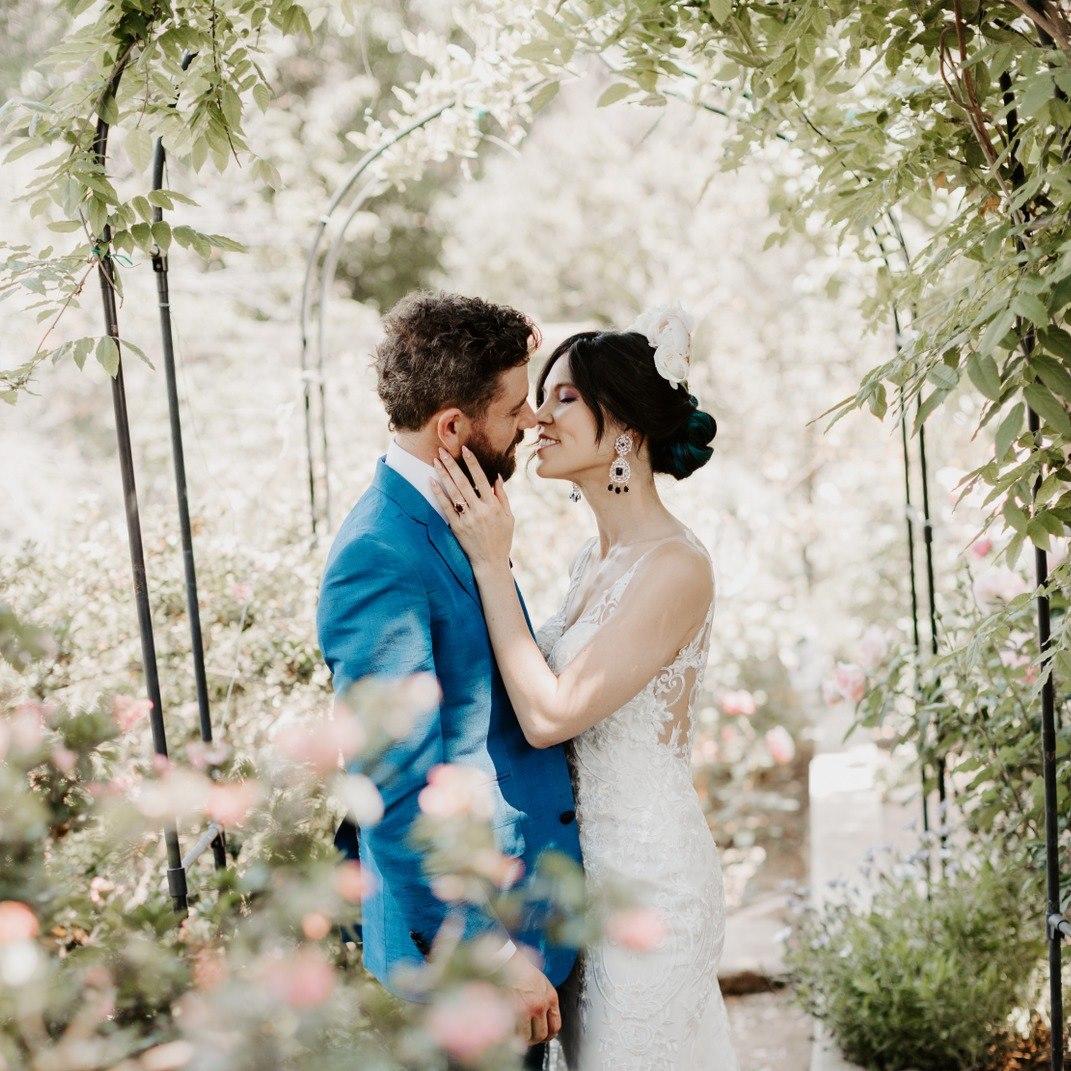 groom in blue and bride in white almost kissing