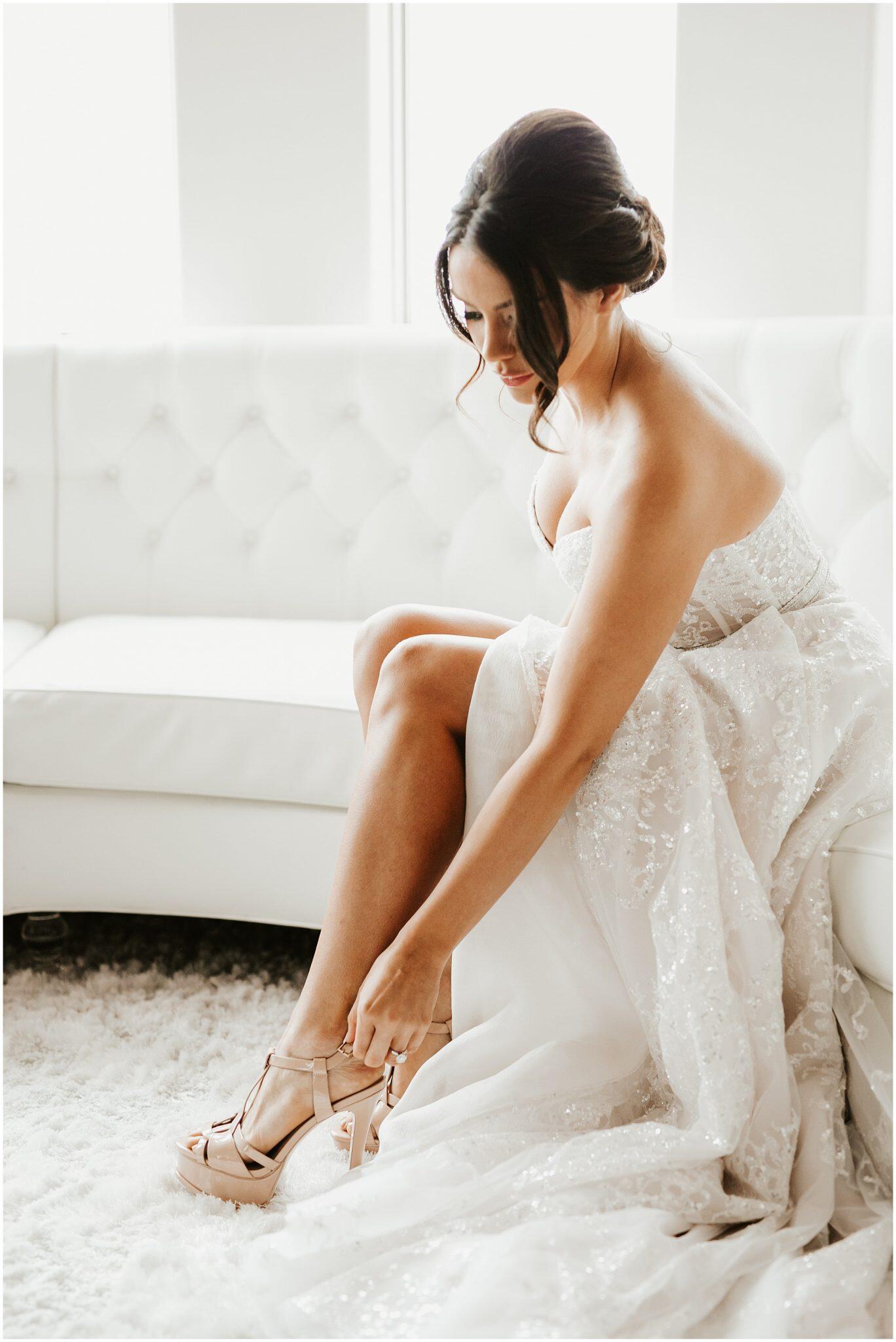 Portrait of a bride getting ready and wearing her shoe