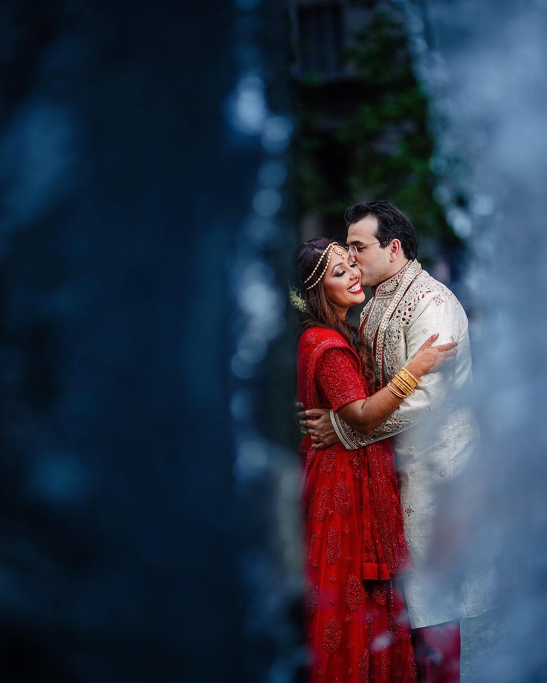 A bride and groom holding each other and posing for a kiss