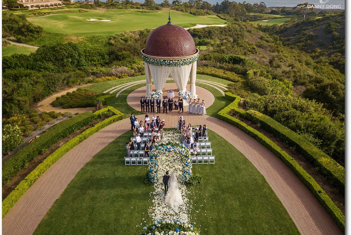 Bird's-eye view of a couple walking down the aisle at an outdoor wedding ceremony