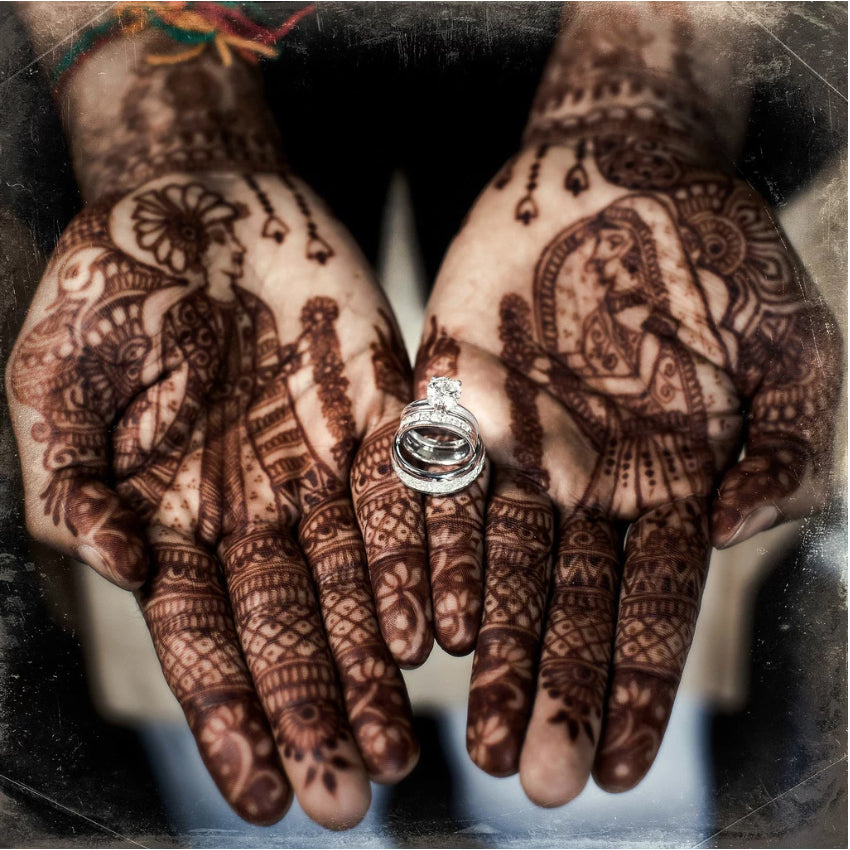 Close up of a bride's heena tattooed hands with the engagement ring 