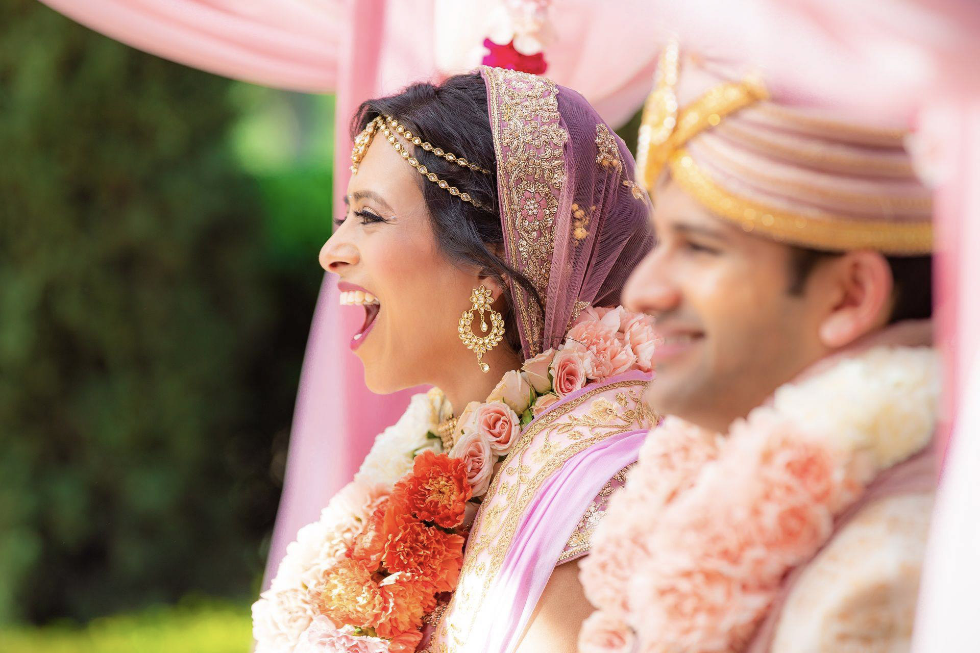 Close up portrait of an Indian couple smiling and cheering after getting married