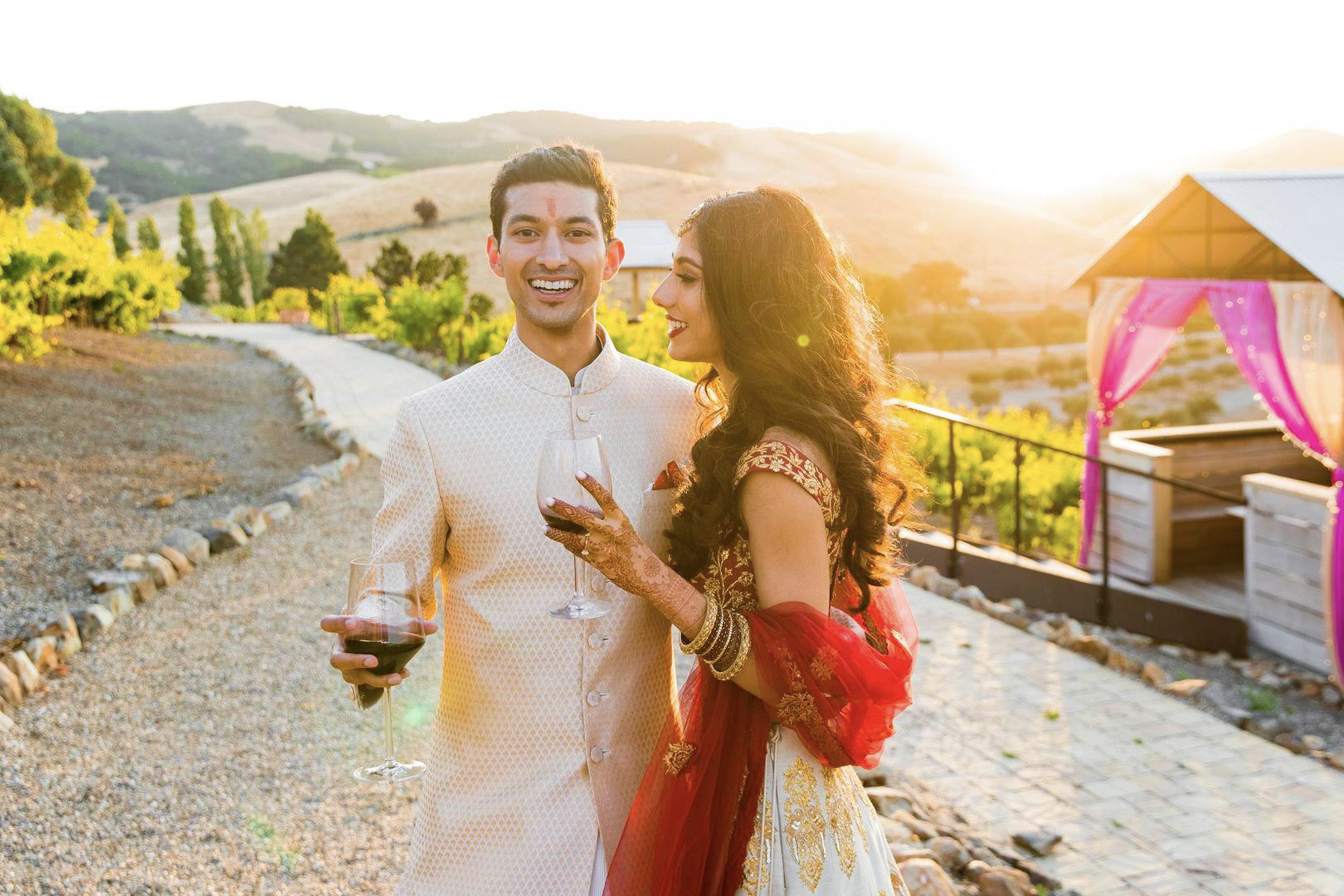 Indian couples posing in a pre-wedding event while holding wine