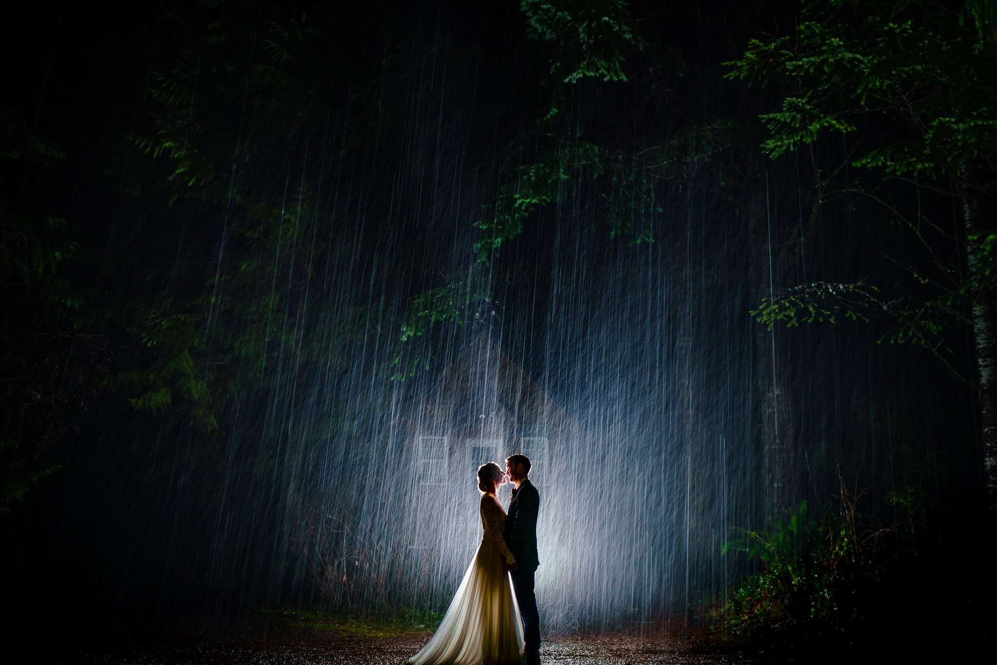 Silhouette of a couple holding hands while facing each other in the rain