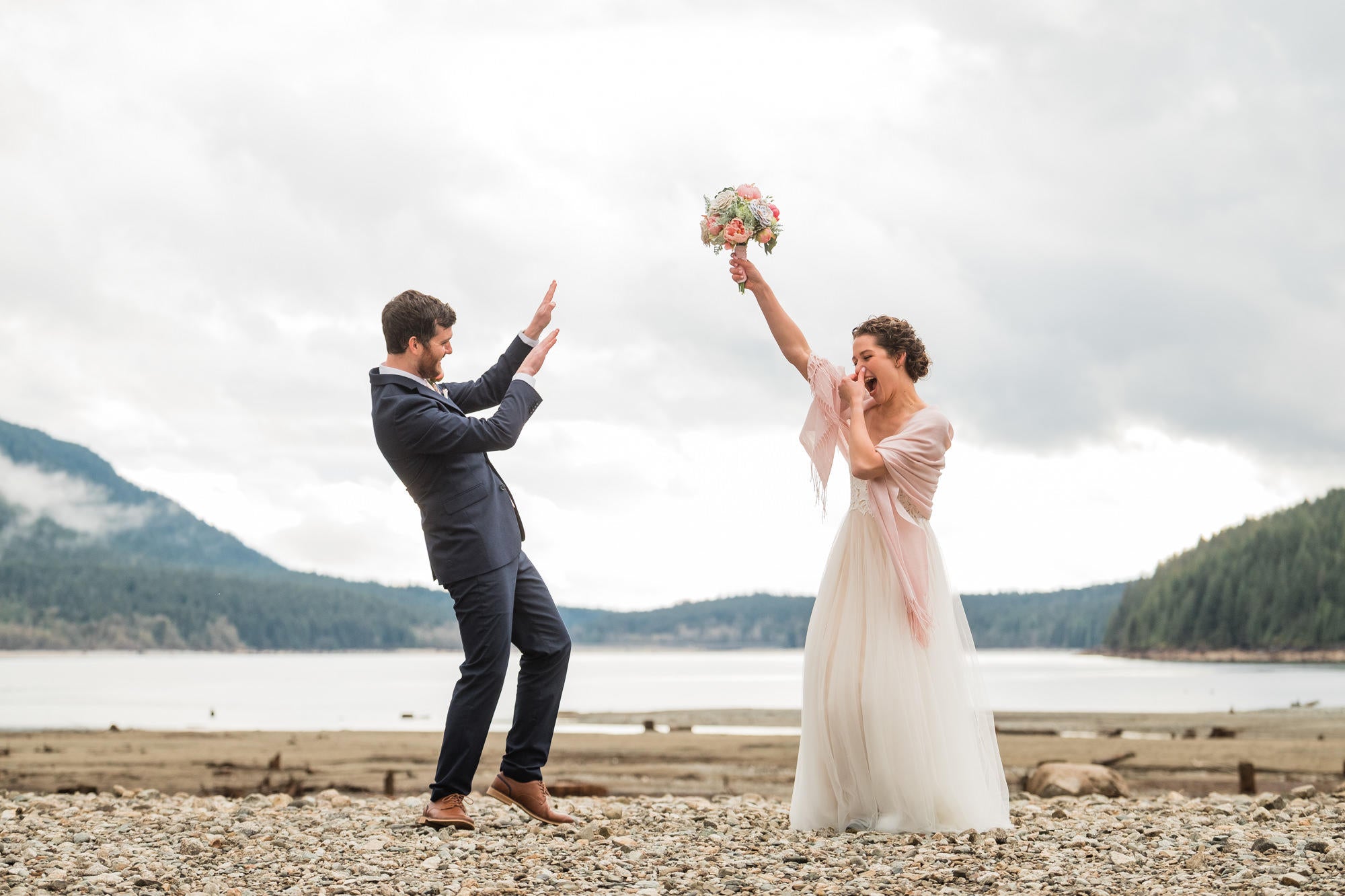 wedding couple doing a funny dance on a beach