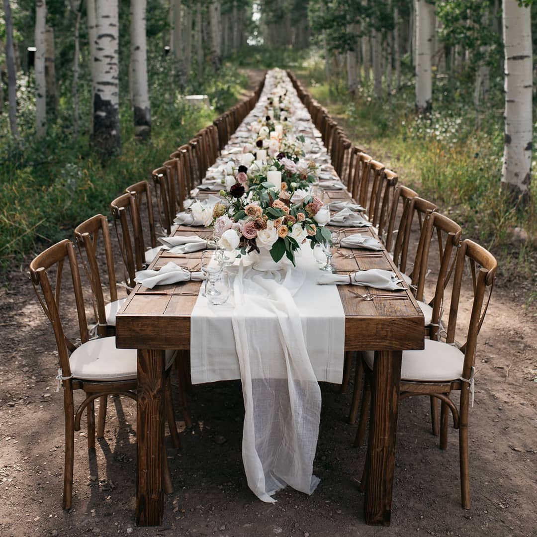 A banquet table set for a reception dinner at an outdoor setting