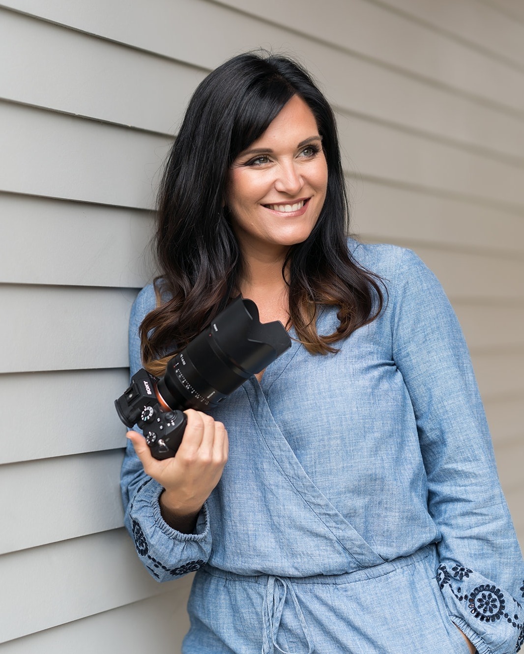 A portrait of Sara France holding a Sony  camera