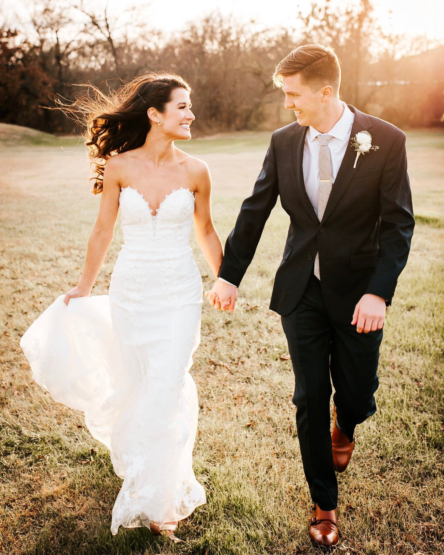 A bride and groom walking while holding hands