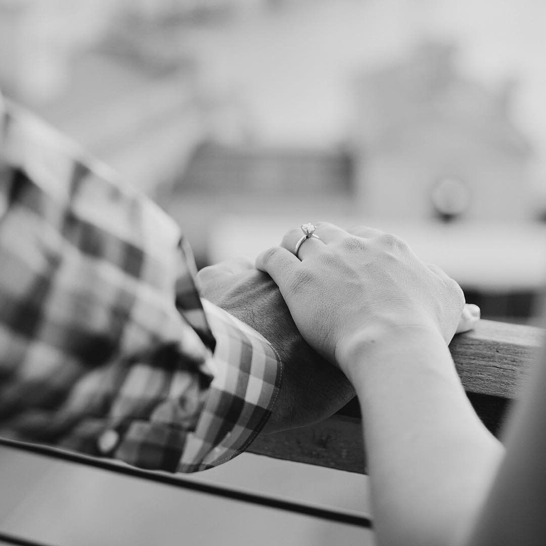 A close up shot of a couple holding hands