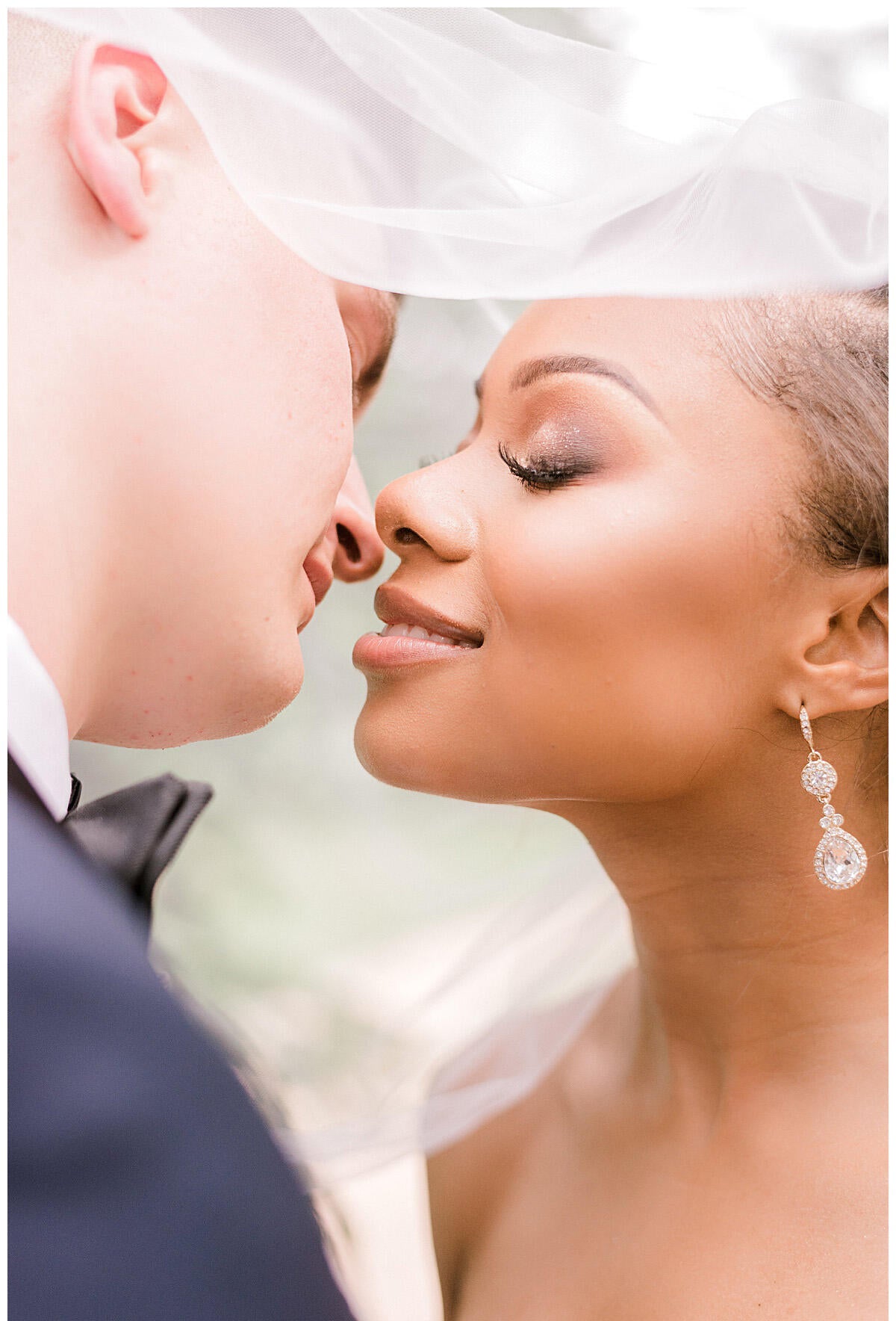 bride and groom almost kissing under veil