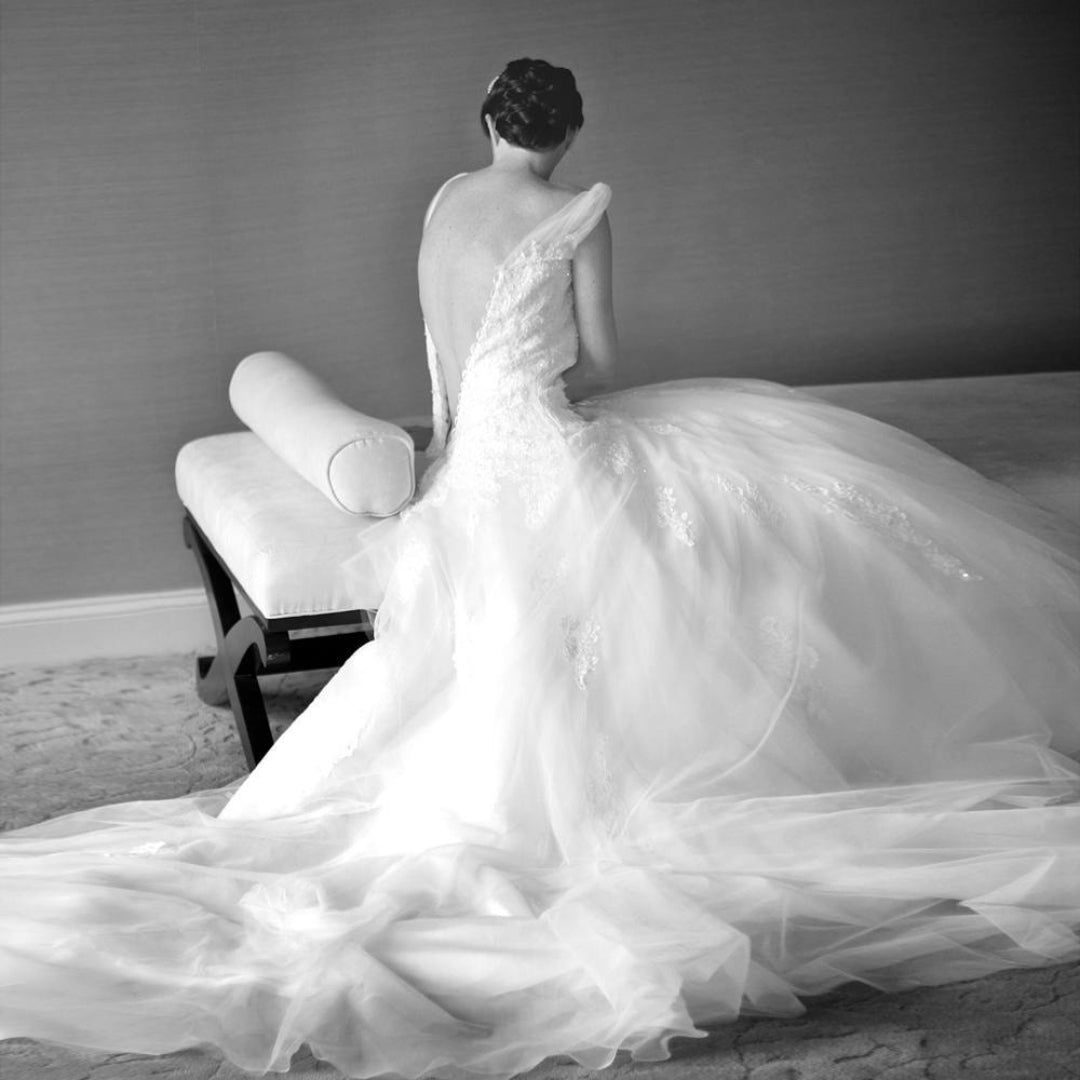 Black and white image of a bride getting ready and putting on her wedding dress