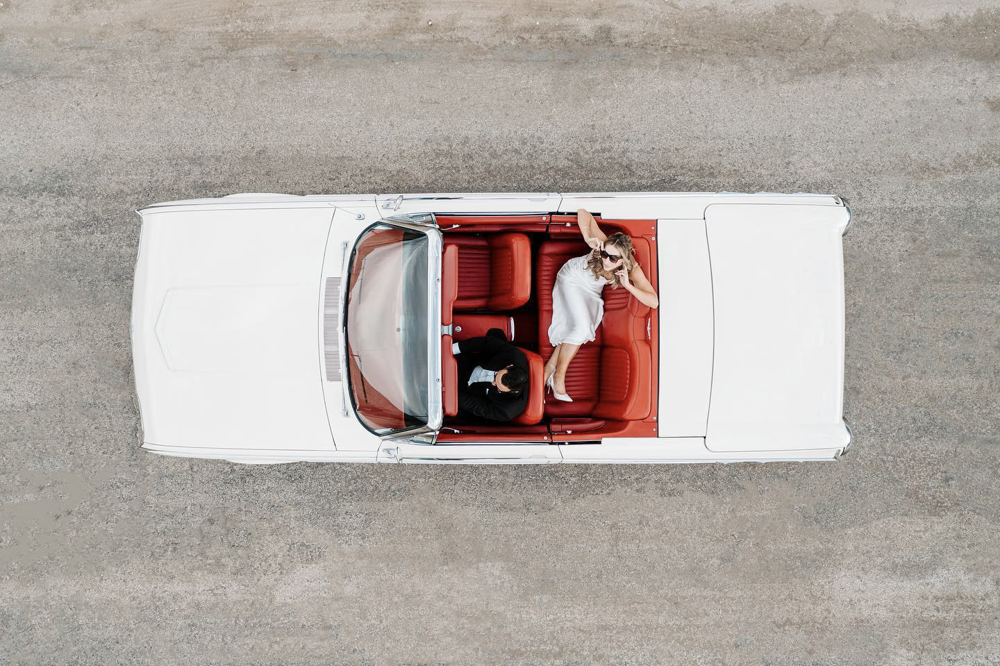 a top down shot of the wedding couple on a car