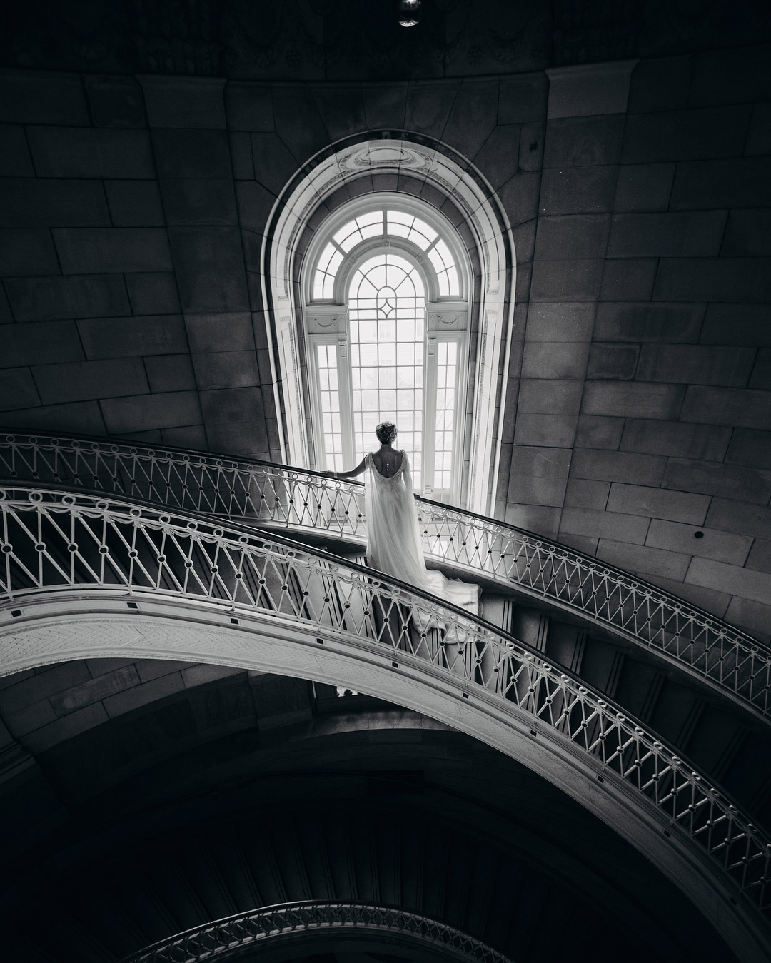 a wedding bride on a staircase looking through a big church window