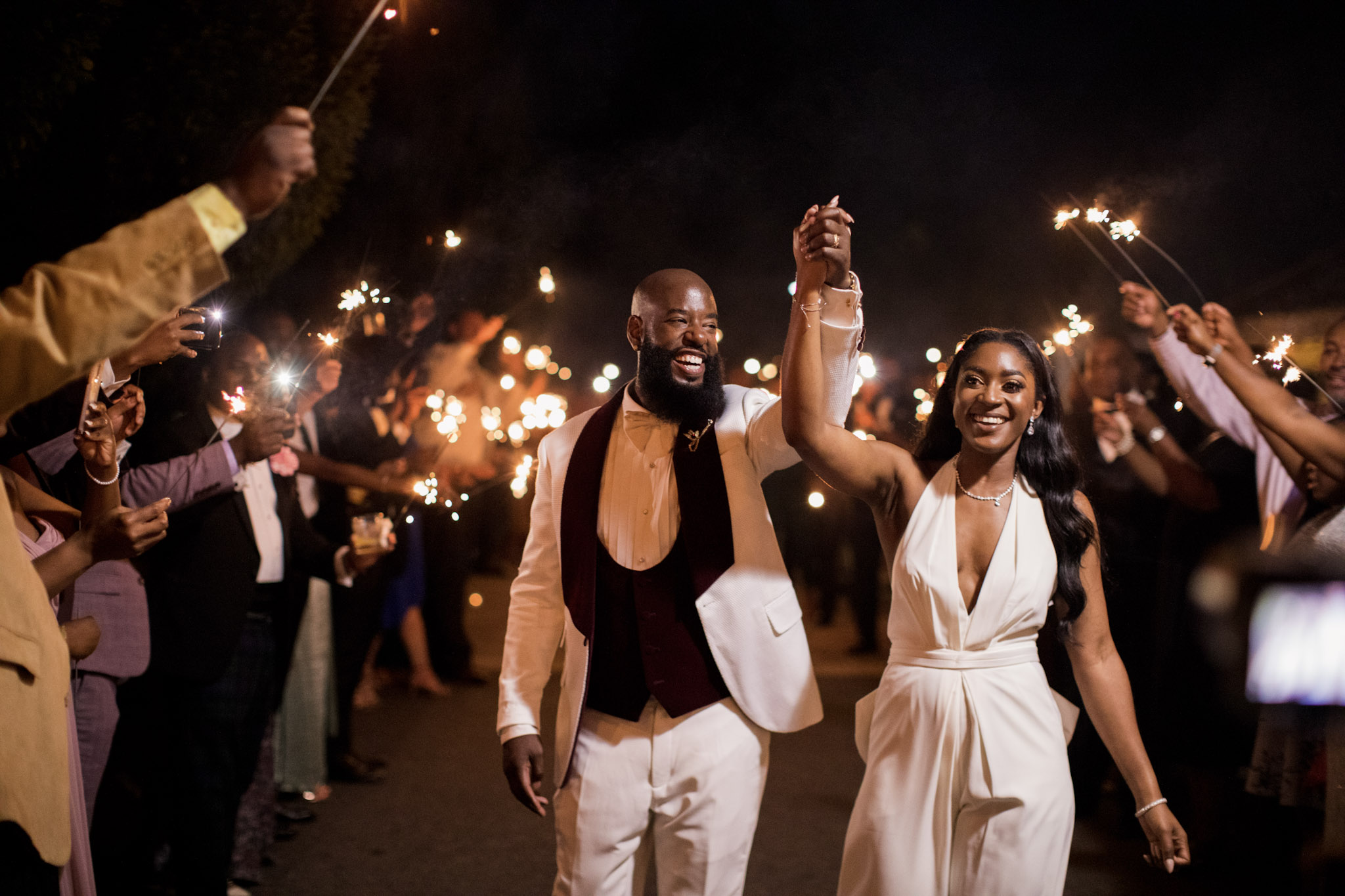 the wedding party giving a sparkler exit to the newlywed bride and groom