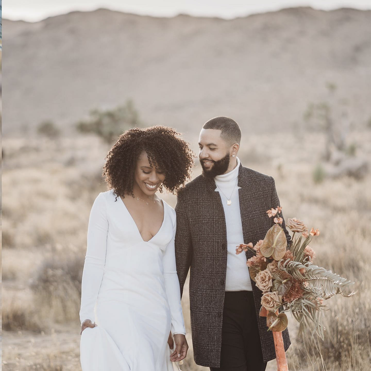 a portrait wedding couple in their wedding attire walking together 