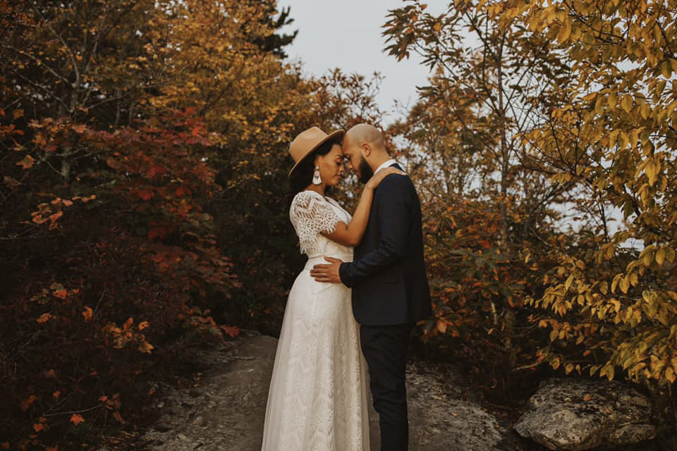 a couple surrounded by greenery is sharing an intimate moment