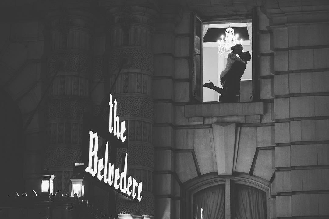 An open window at The Belvedere featuring a silhouette of a couple kissing