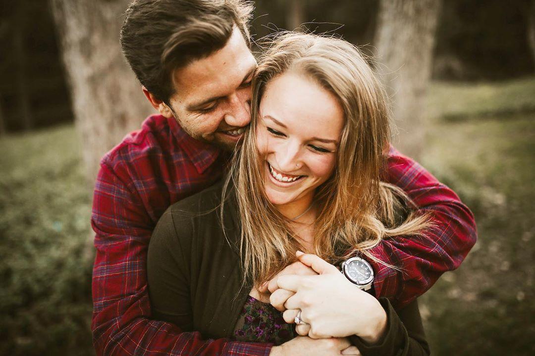 man hugging woman from behind and laughing by Brandi Allyse Photography