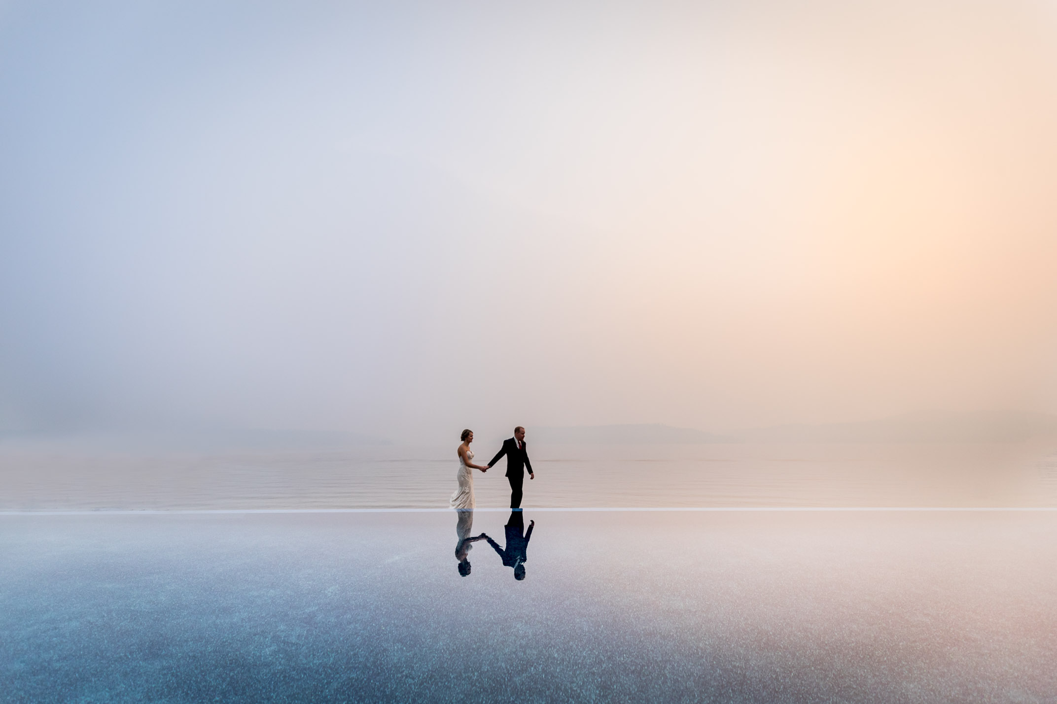 A mirror-like reflection of a couple posing near a waterfront.