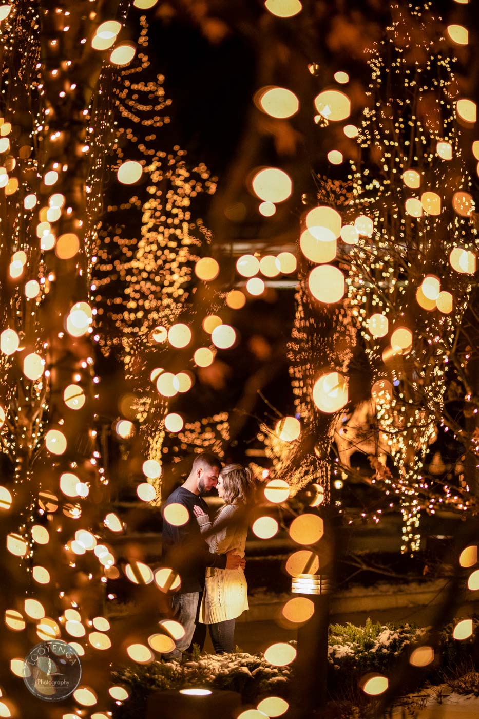 A couple holding each other with a bokeh background