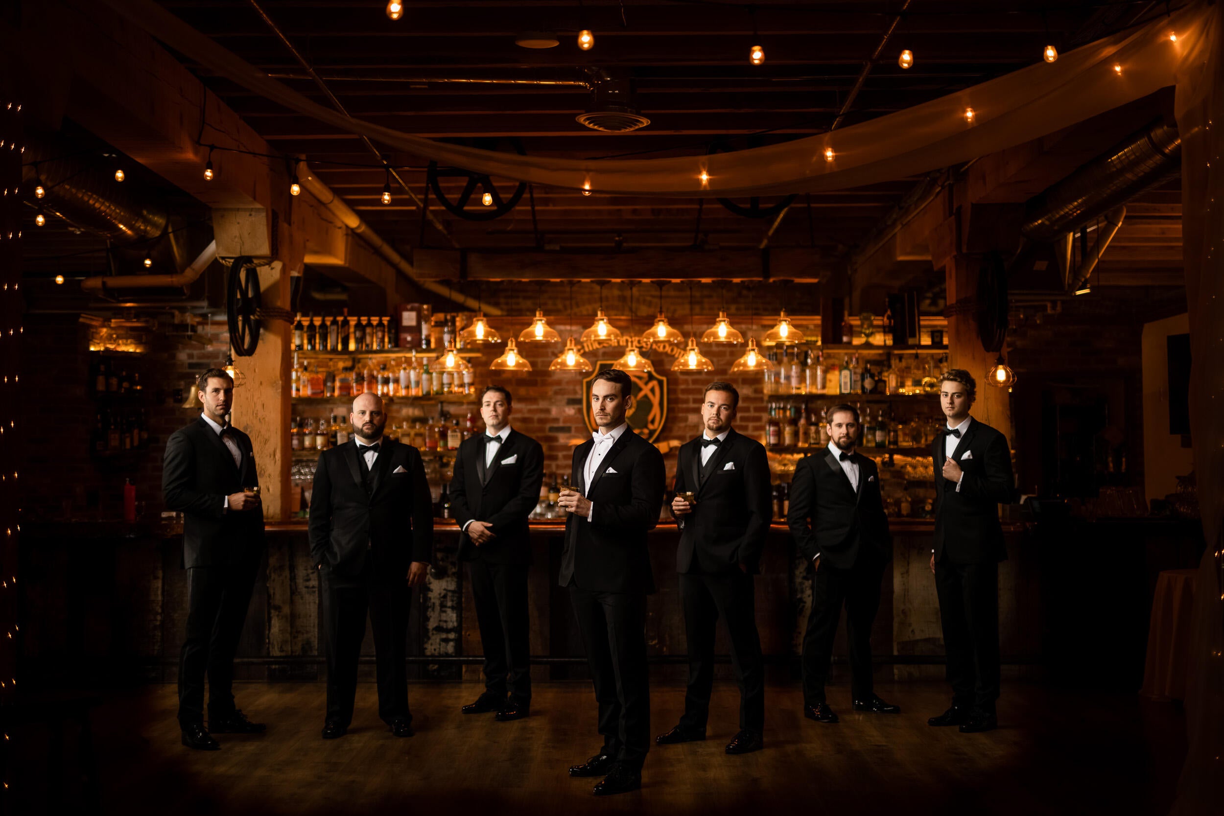 groomsmen standing at bar with groom