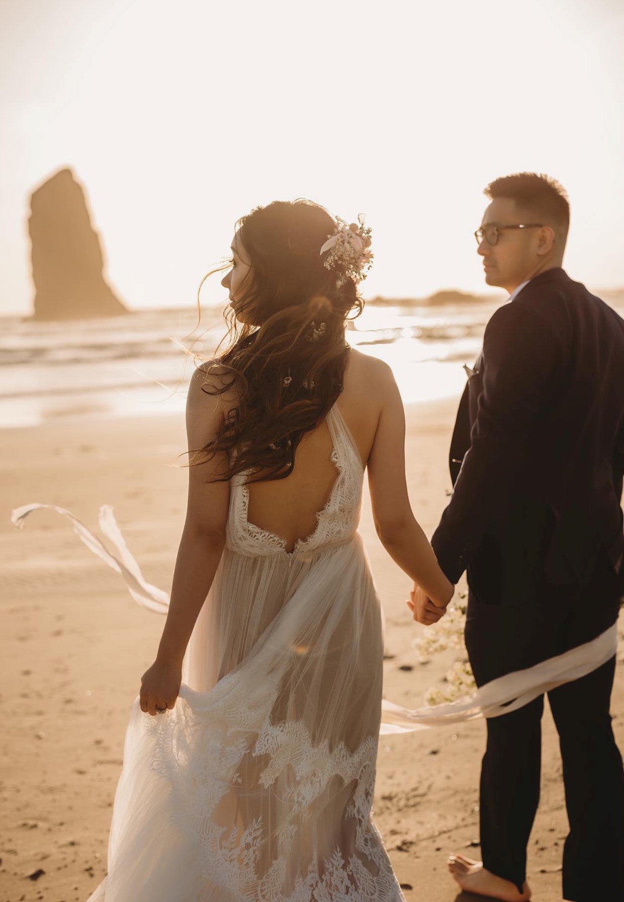 A bride and groom posing while holding hands