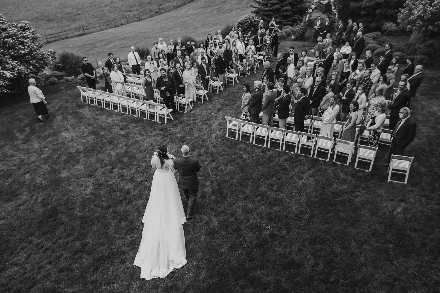 an aerial shot of a wedding bride walking down the aisle