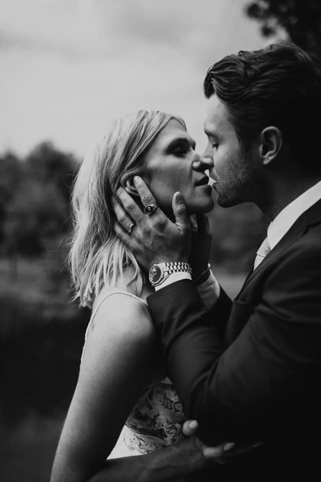 a black and white image of a wedding couple kissing