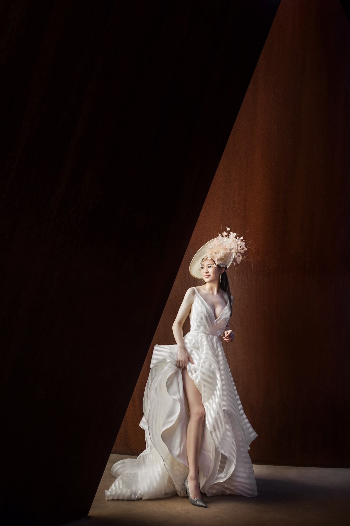 a bride posing in wedding attire in front of a wooden background