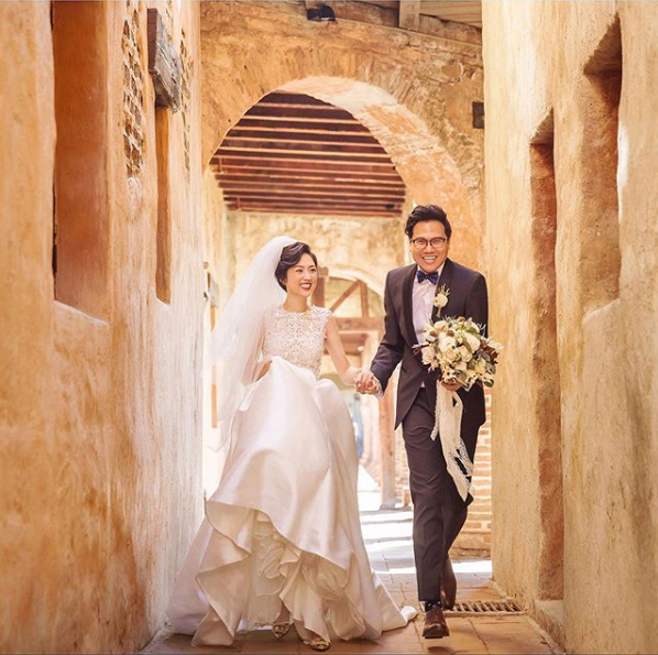 a married couple on their grand exit after the wedding with flower in hand