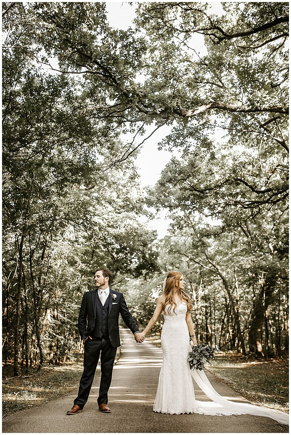 a couple in their wedding attire standing holding hands and looking at opposite direction