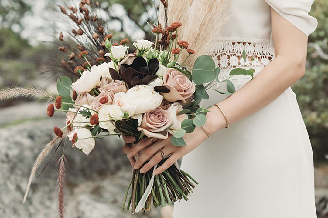 Mid closeup shot captured by Diane (female photographer) of a bridal bouquet in the hands of the bride