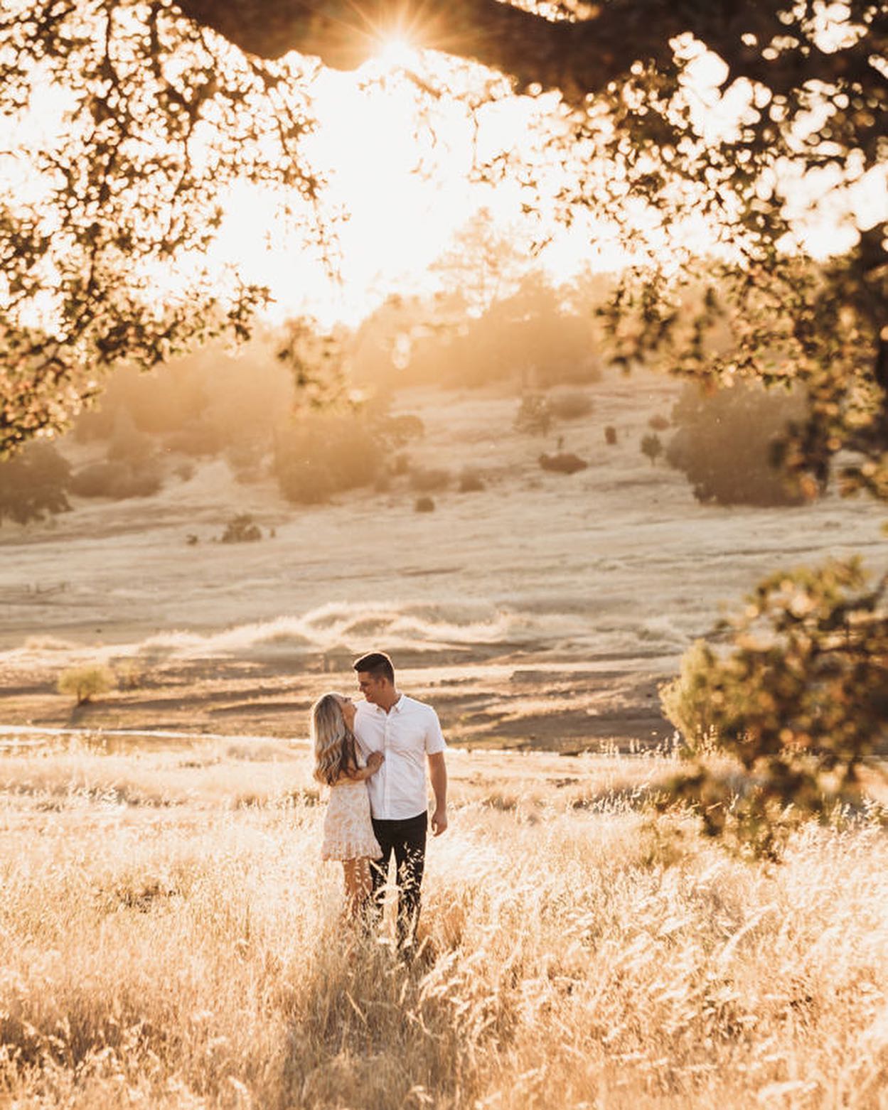 A couple holding together while posing during an engagement session somewhere outdoors