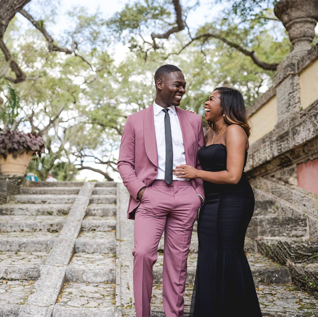 a couple looking at each other standing on some stairs