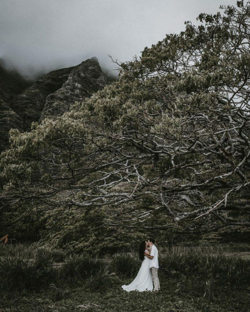 a couple kissing below a tree 