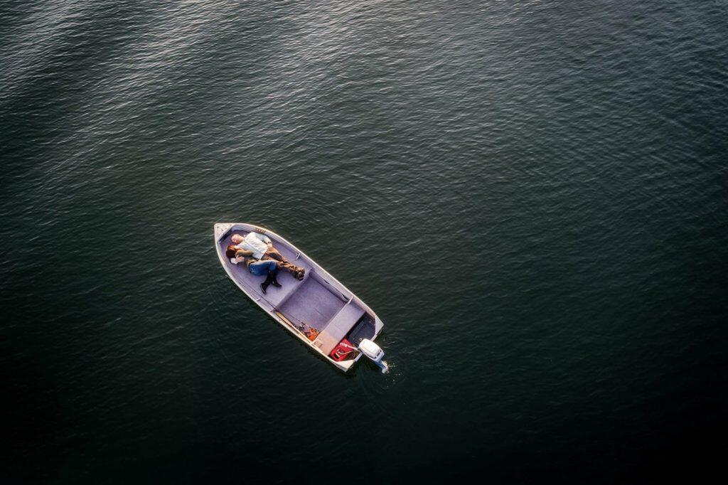 a aerial shot of a couple lying down in a boat