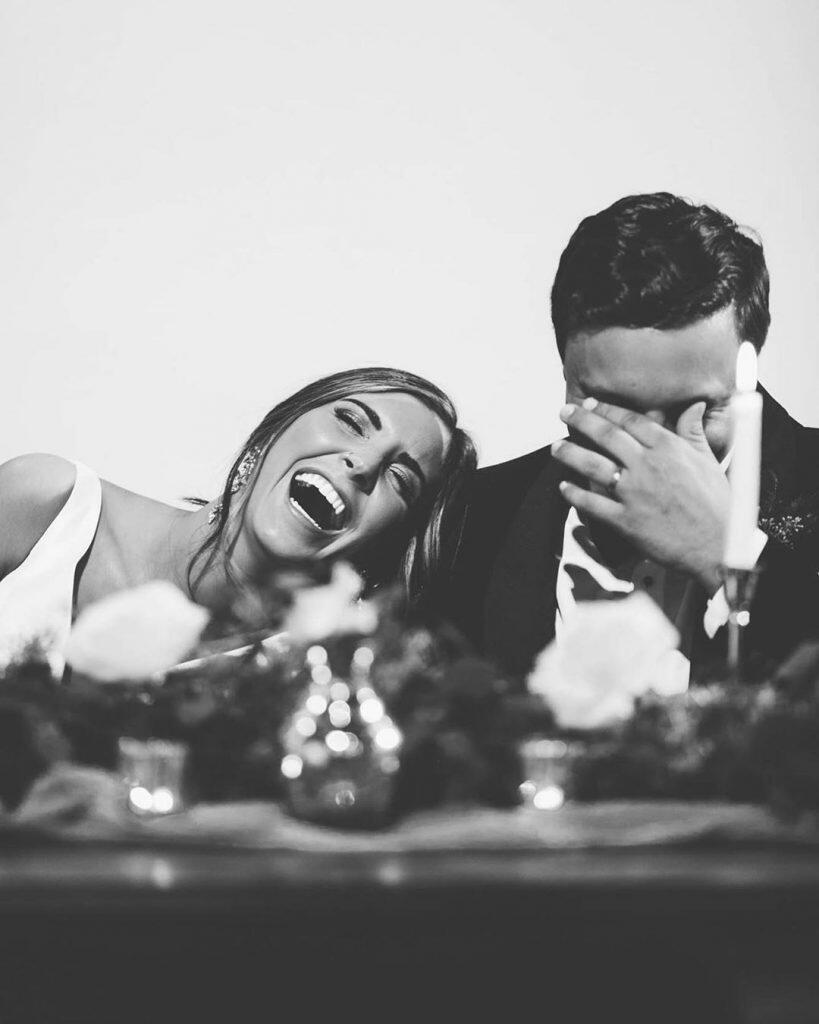 a black and white image of a couple laughing out loud