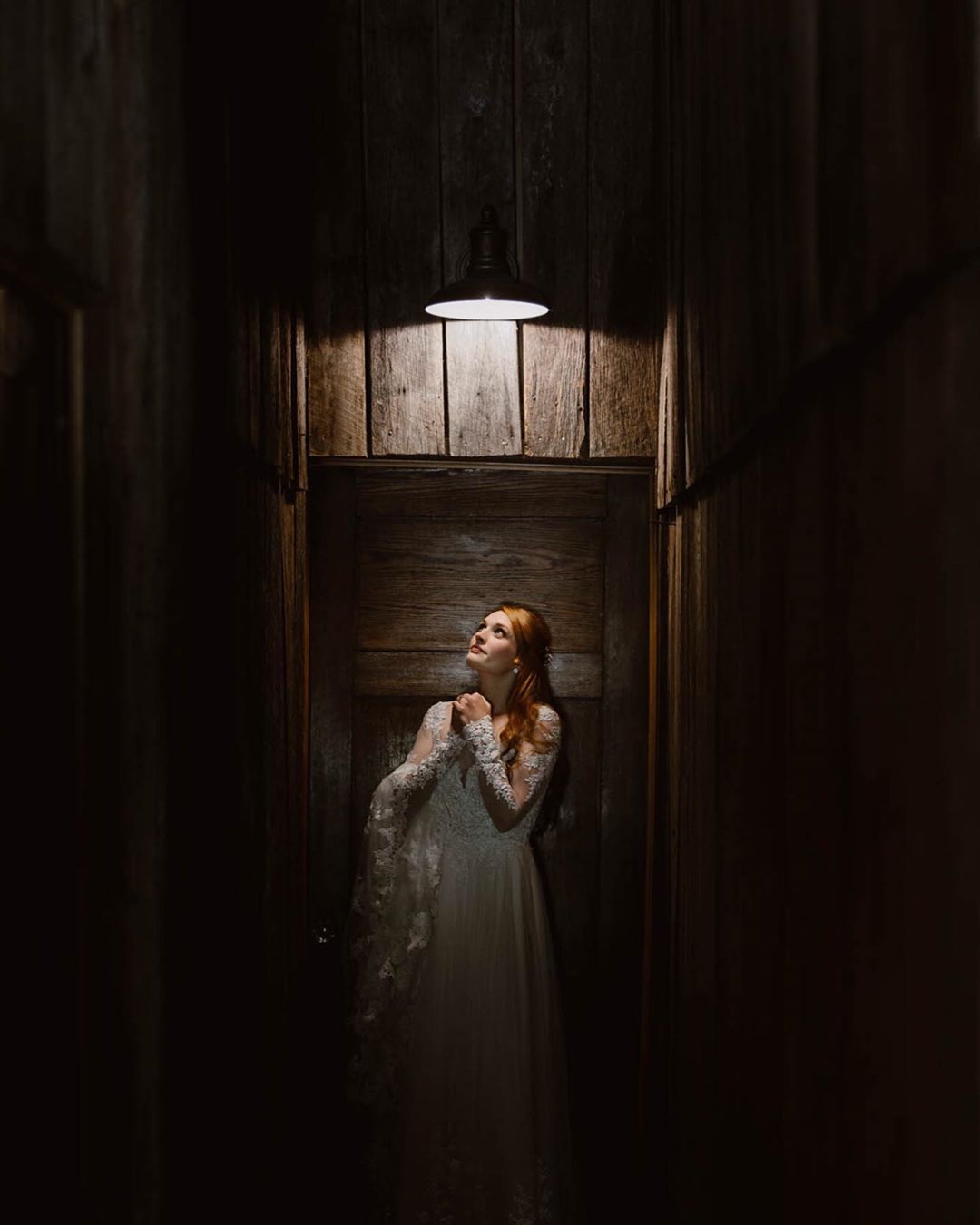 Portrait of a bride standing right the light source in an enclosed space