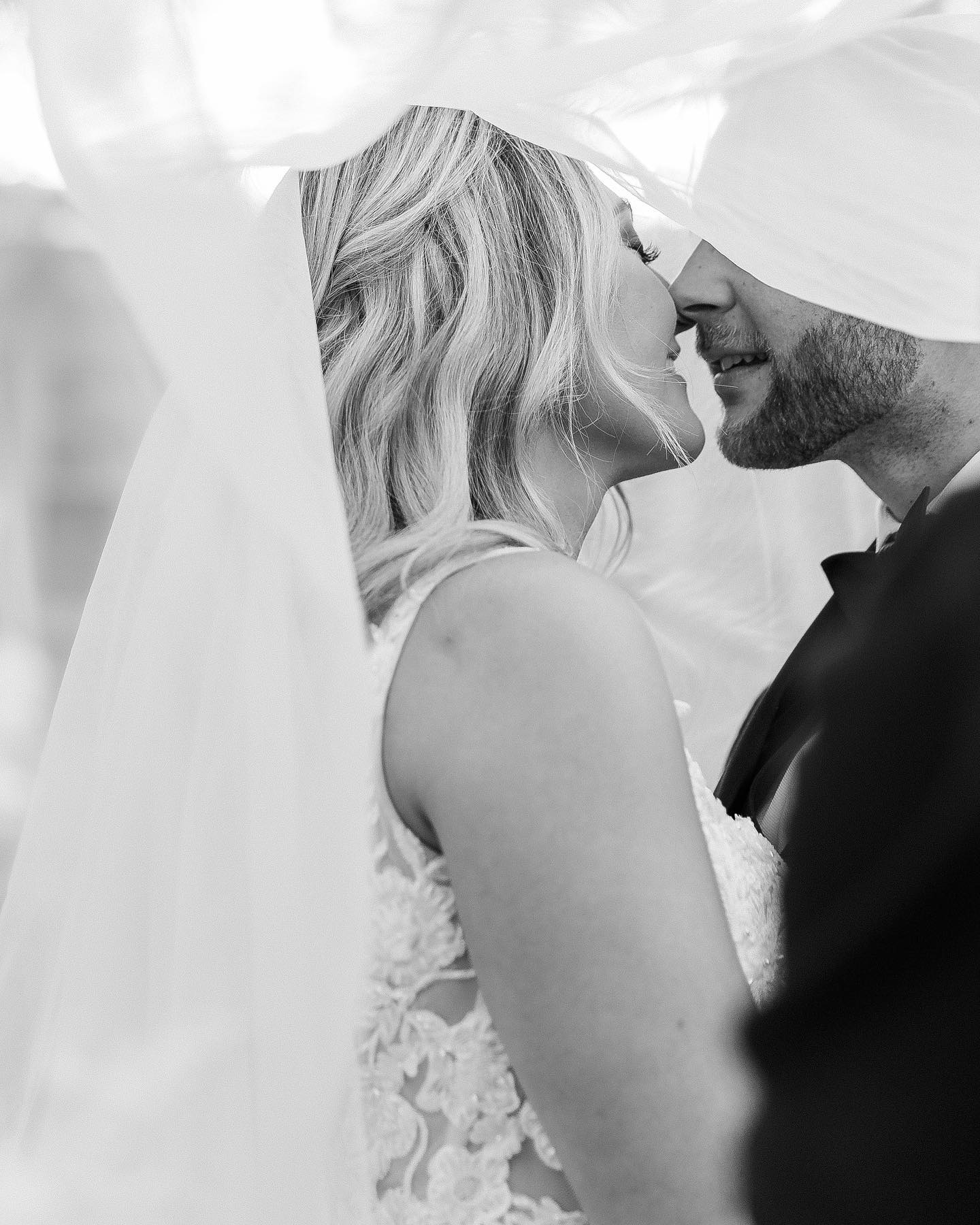 a wedding bride and groom sharing an intimate moment under the wedding veil