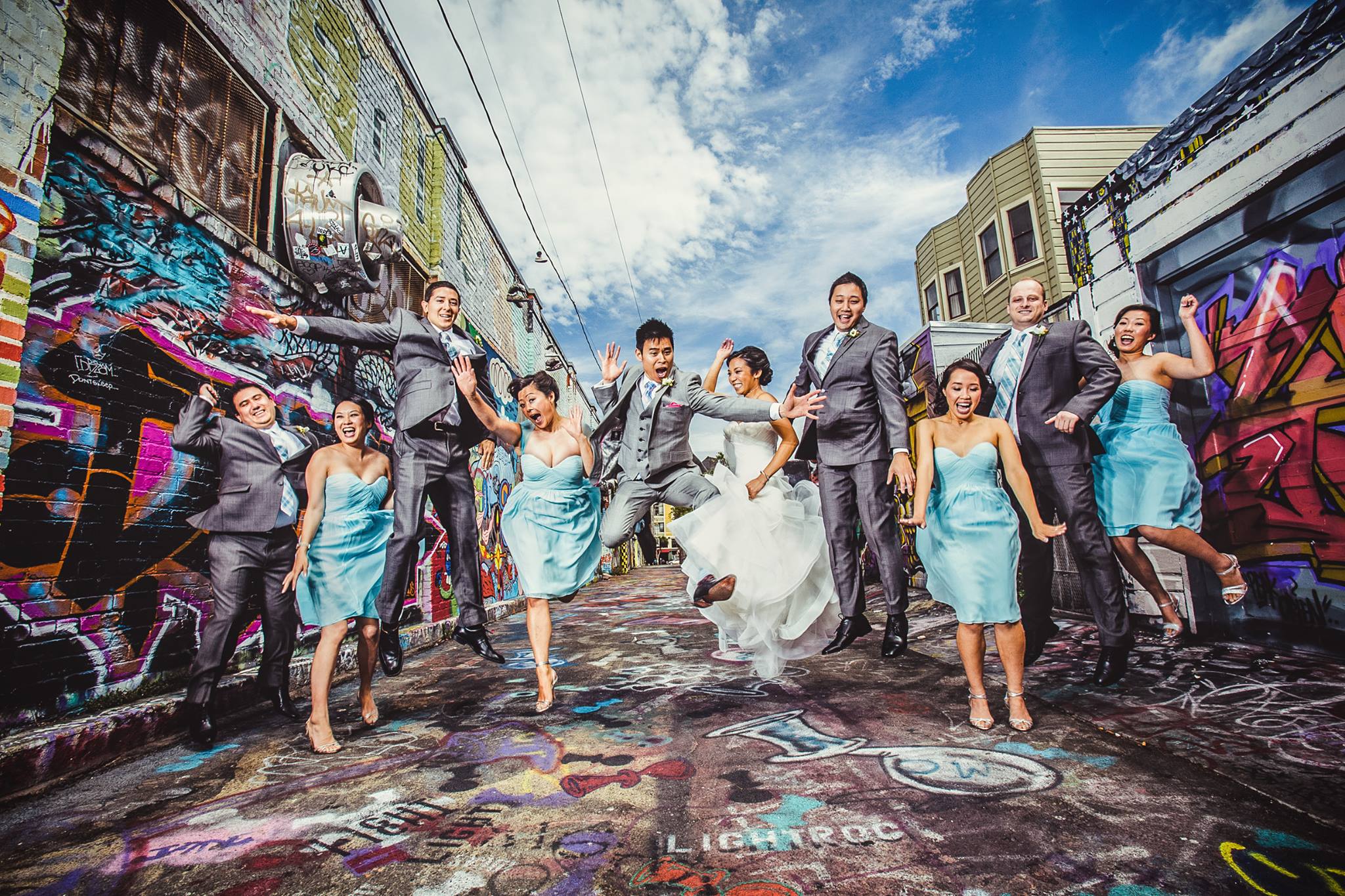 A bride and groom with their bridesmaids and groomsmen trying out a jump shot