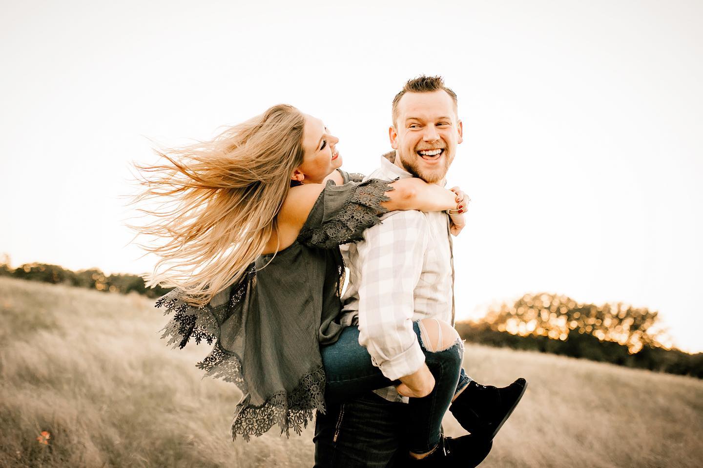 A portrait of a couple where the girl has climbed up on the guy’s back