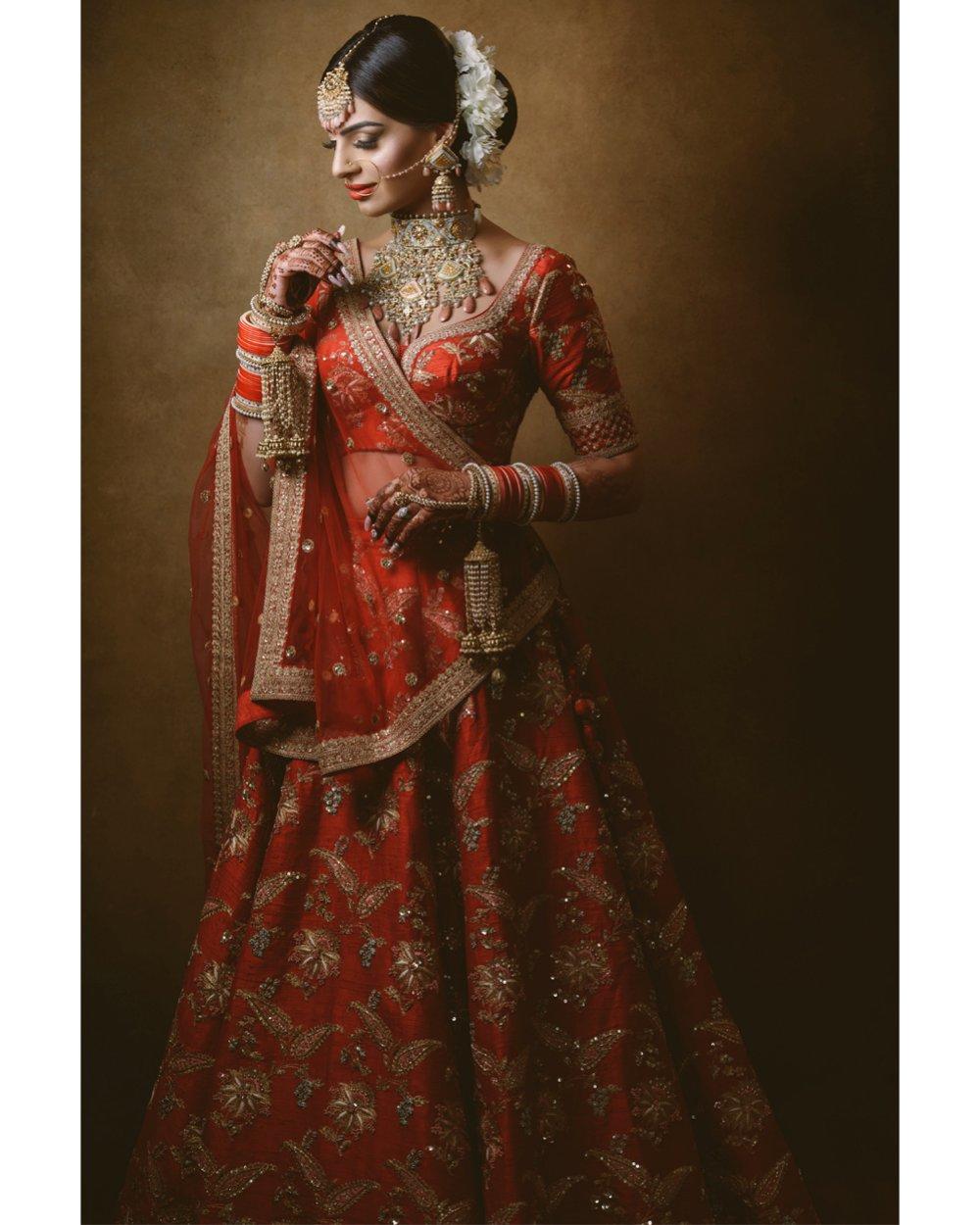 A bride posing in a red Indian wedding dress - ShootDotEdit feature of how to navigate gear-specific questions from clients