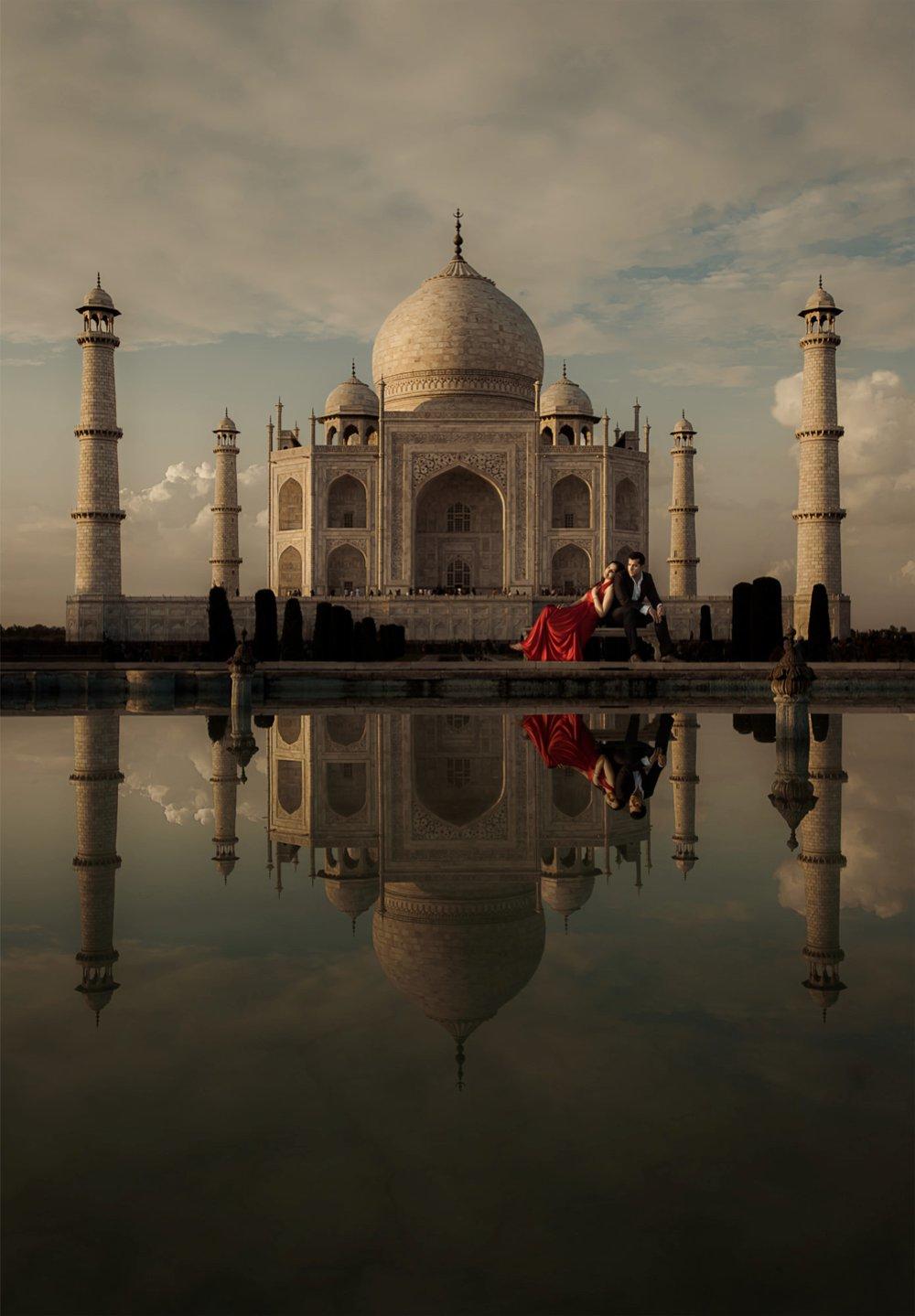 A couple posing in front of the Taj Mahal in India