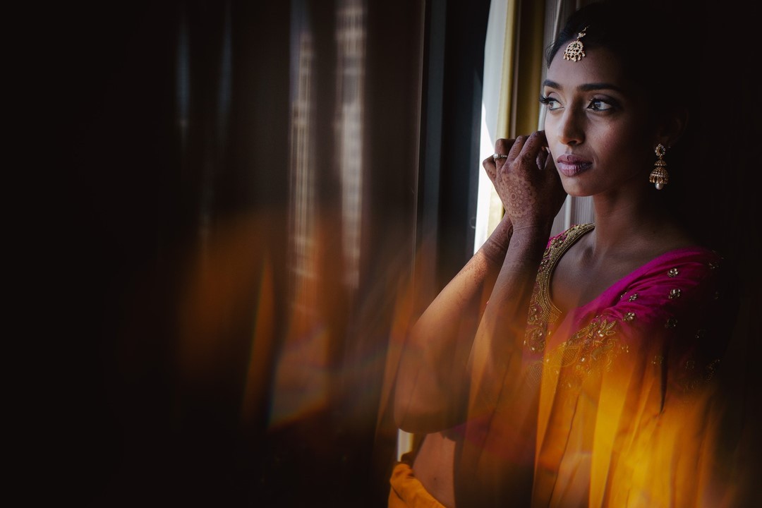 A portrait of a bride putting on her earrings