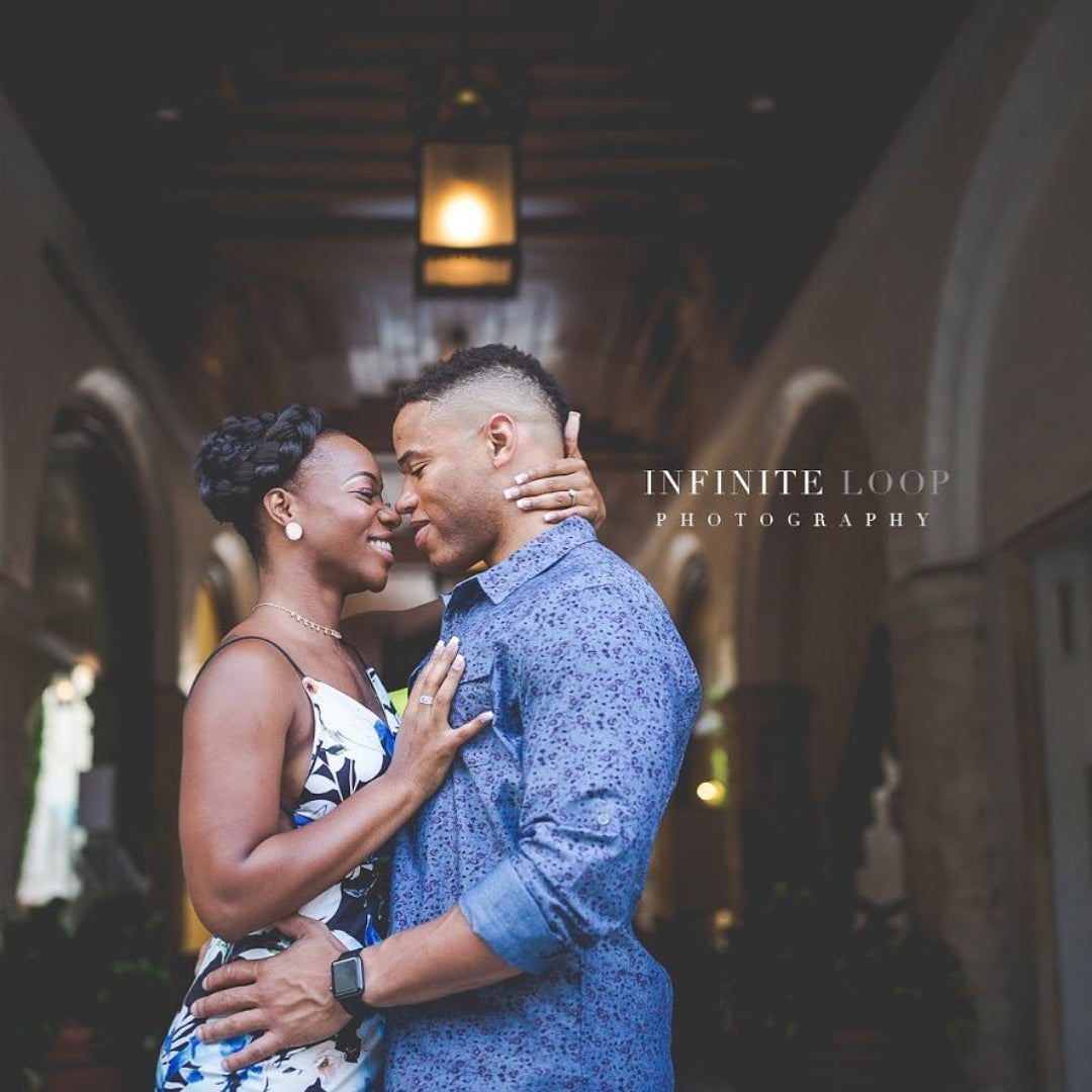 A couple of color holding each other and posing for an engagement session